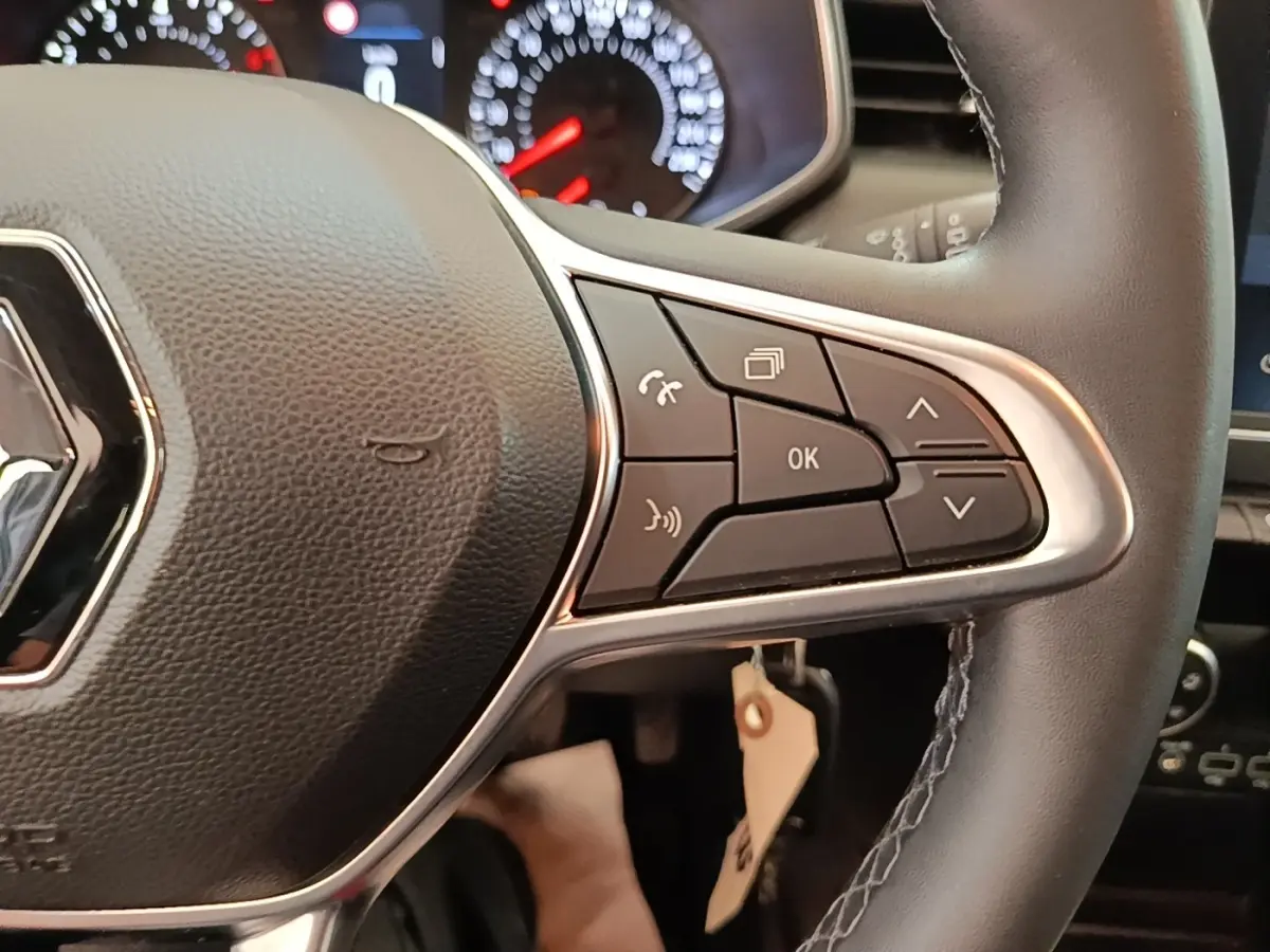 Gros plan sur le volant multifonctions en cuir synthétique de la Renault Clio Business TCe 100, avec commandes intégrées.