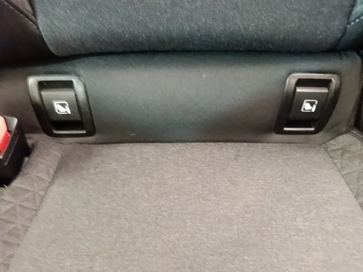 Détail des commandes de rabattement des sièges arrière sur la banquette d'une Renault Clio Business gris foncé.
