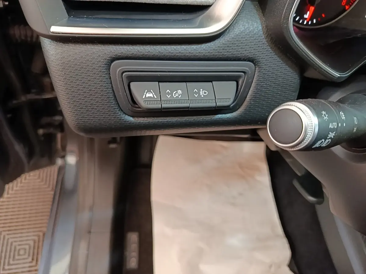 Vue intérieure du tableau de bord côté gauche de la Renault Clio Business TCe 100, avec commandes d'assistance à la conduite.