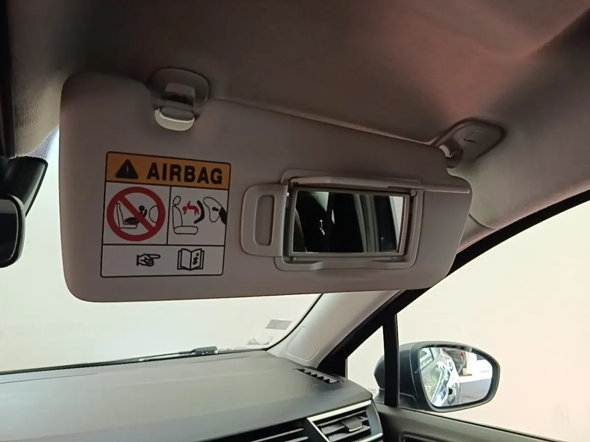 Vue intérieure côté droit sur le pare-soleil avec miroir et avertissement airbag dans une Renault Clio gris foncé 2021.