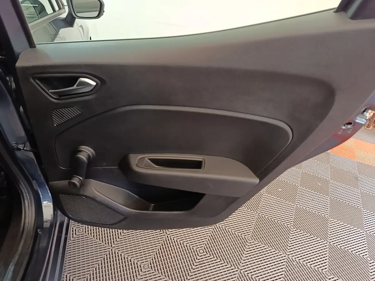 Vue rapprochée de la porte arrière gauche gris foncé de la Renault Clio Business TCe 100 avec manivelle de vitre manuelle.