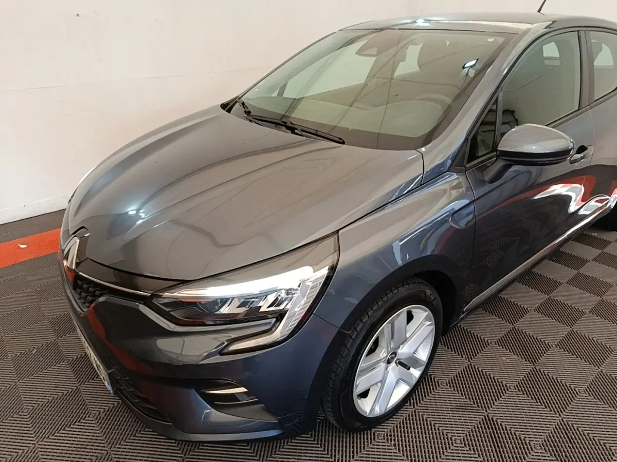 Renault Clio Business TCe 100 gris foncé vue 3/4 avant droit, avec phares LED et jantes alliage visibles.