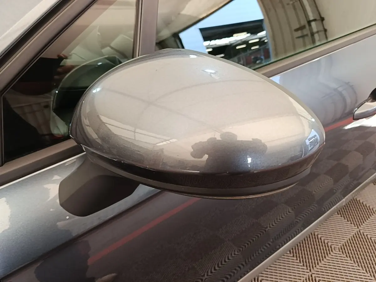 Rétroviseur côté gauche gris foncé de Renault Clio Business TCe 100 2021, avec reflet et partie de la portière visible.