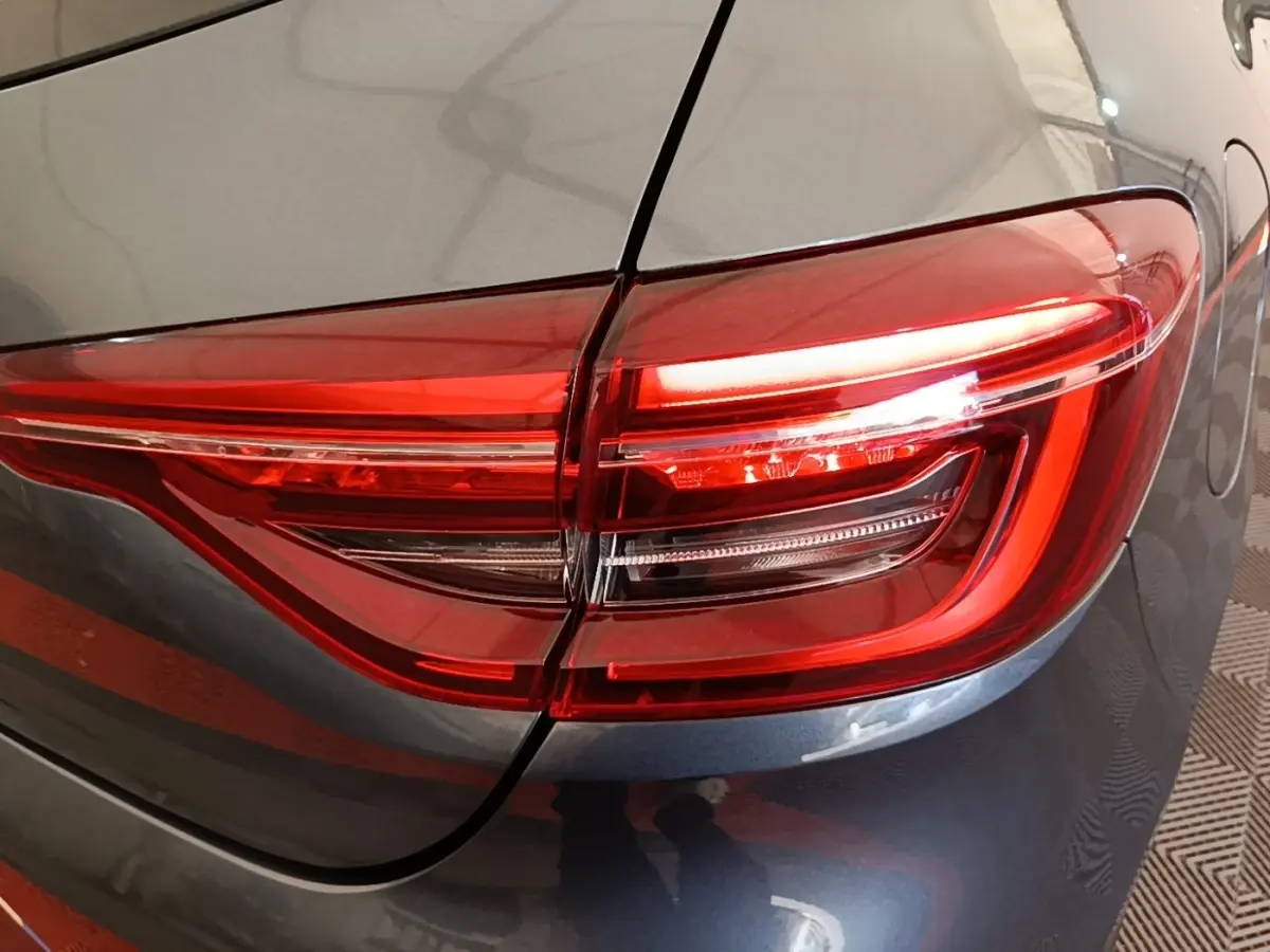 Gros plan sur le feu arrière droit rouge d’une Renault Clio Business TCe 100 gris foncé de 2021.