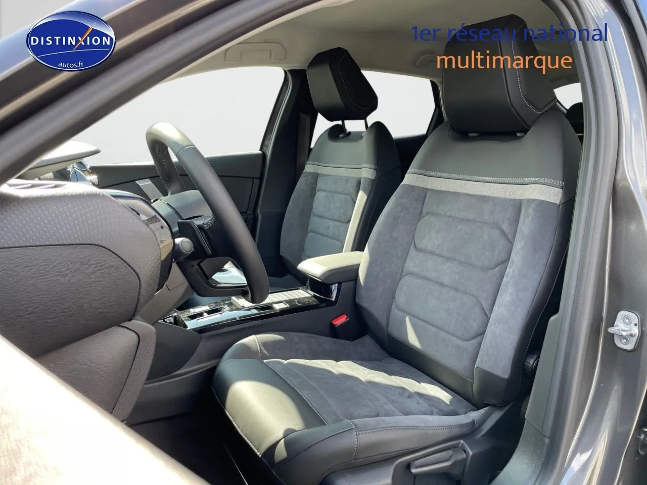 Vue intérieure côté conducteur d'une Citroën C4 gris platinium métal 2024 avec sièges en cuir et alcantara gris.