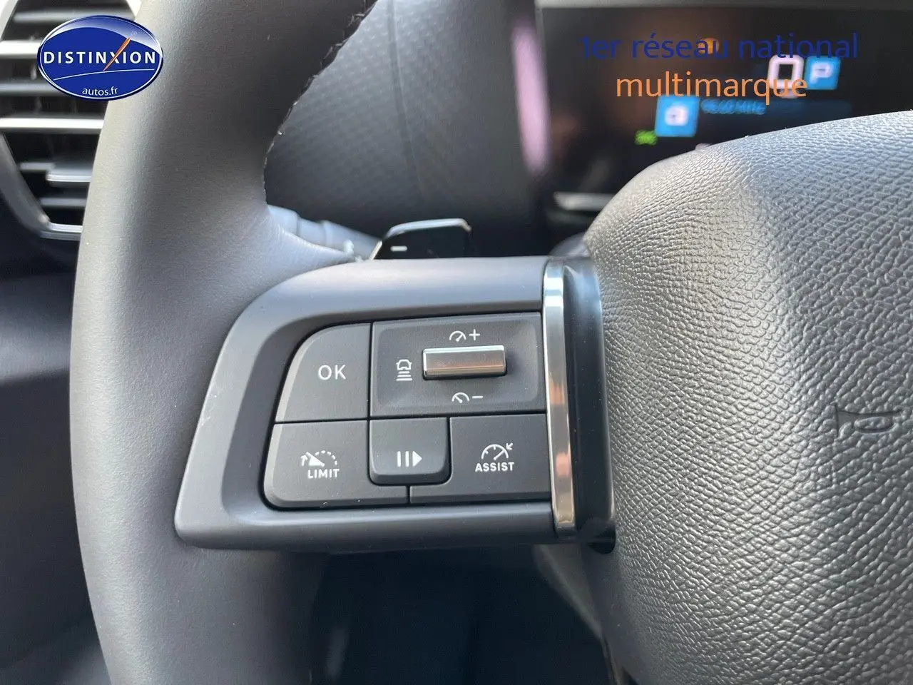 Gros plan sur les commandes au volant de la Citroën C4 gris platinium, mettant en valeur les boutons de régulateur et d'assistance.