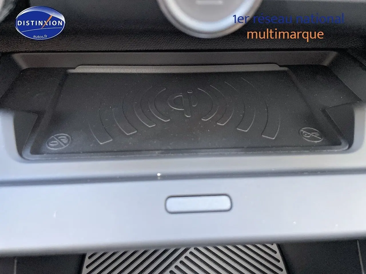 Surface de recharge sans fil Qi en gros plan dans l'habitacle d'une Citroën C4 gris platinium 2024.