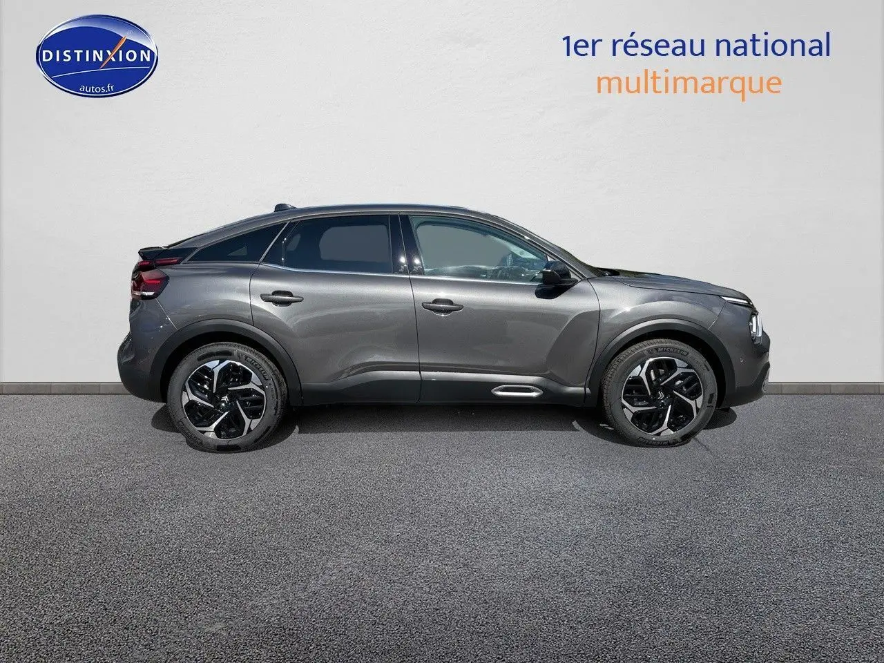 Profil côté gauche d'une Citroën C4 2024 gris platinium métal avec jantes noires et toit noir contrasté.