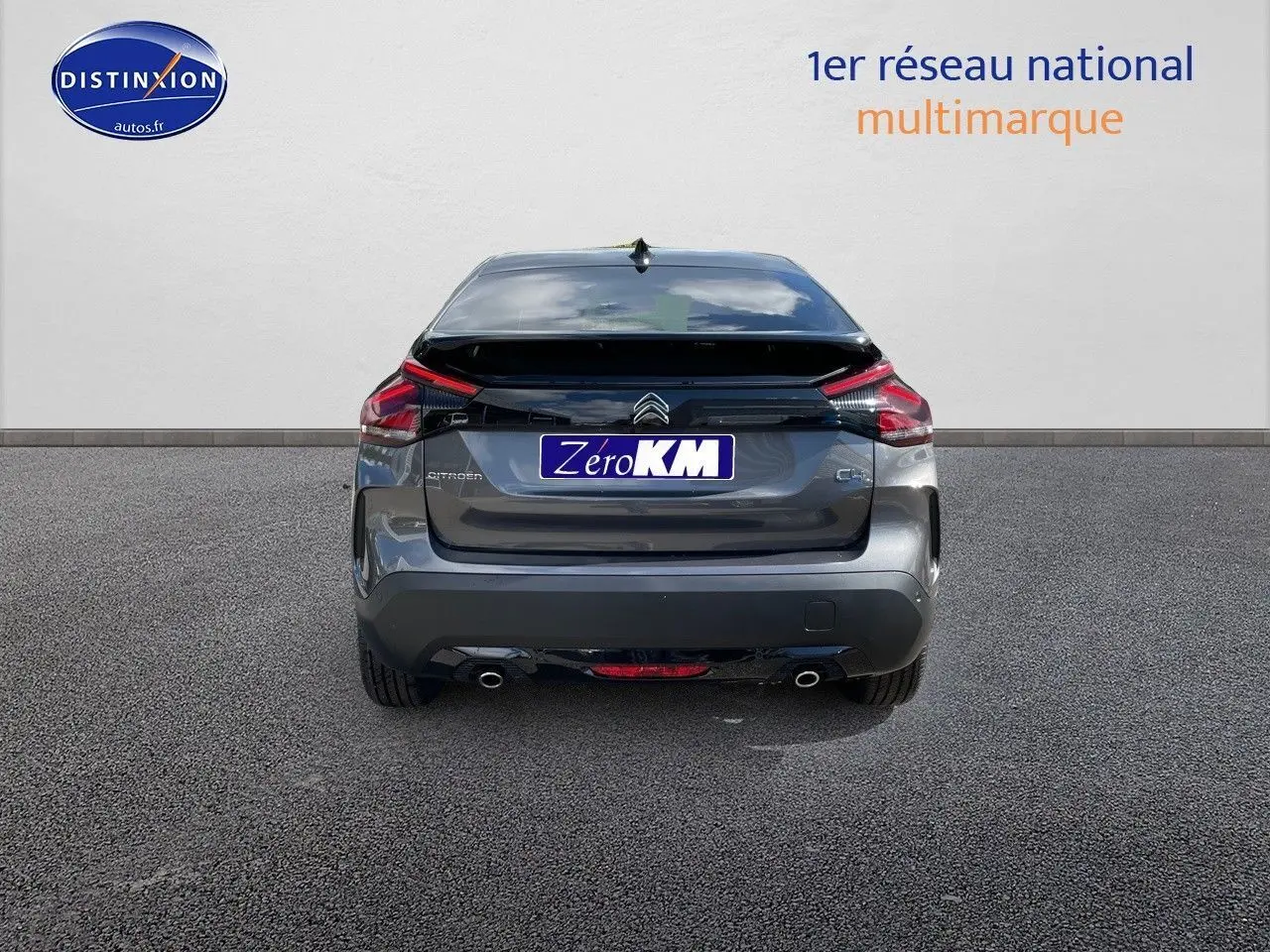 Vue arrière d'une Citroën C4 2024 gris platinium métal avec feux LED et double sortie d'échappement visible.