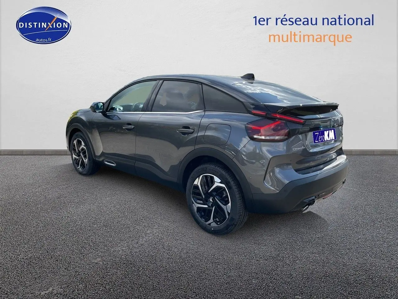 Vue 3/4 arrière droite d'une Citroën C4 2024 gris platinium métal avec jantes biton et feux LED distinctifs.