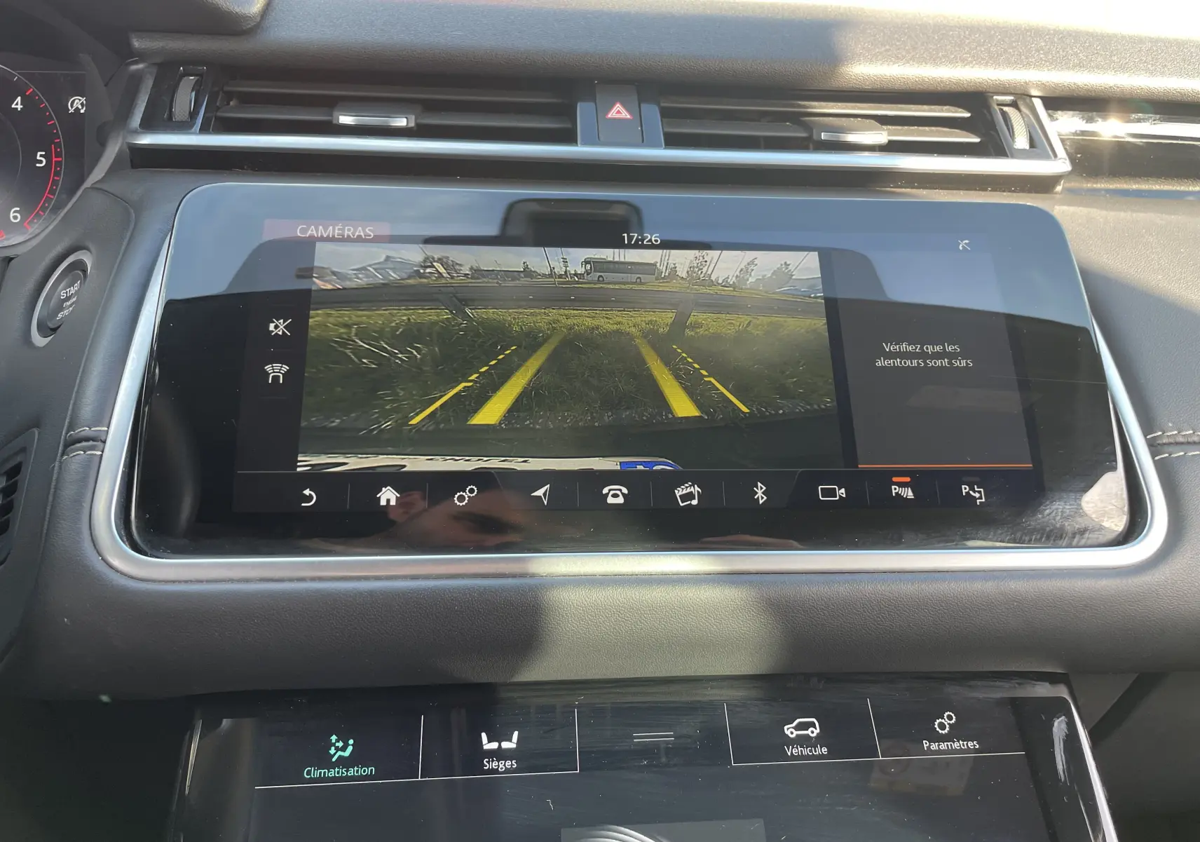 Écran central du Range Rover Velar noir Santorini 2019 montrant la caméra de recul avec lignes de guidage jaunes.