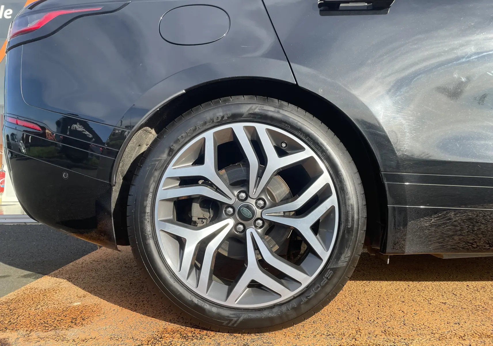 Gros plan sur la roue arrière droite noire Santorini d'un Range Rover Velar 2019 avec jante alliage distinctive.