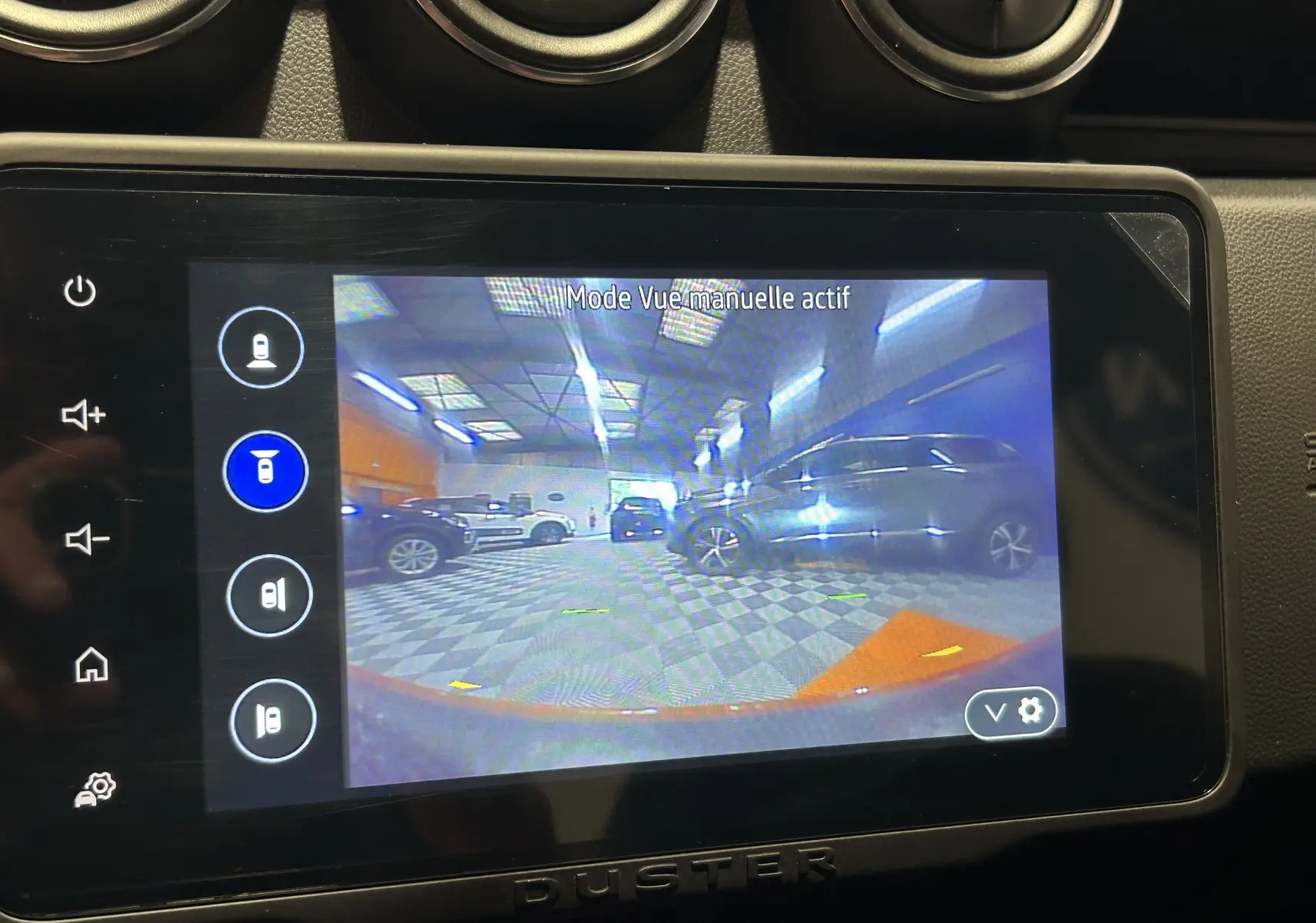 Écran tactile du Dacia Duster 2022 affichant la caméra 360 en mode manuel dans un garage intérieur.