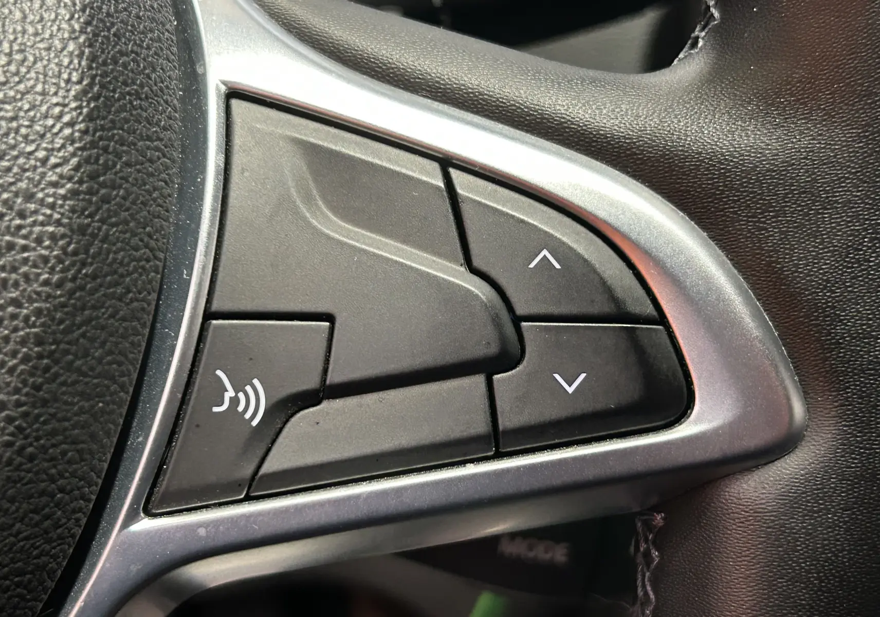 Gros plan sur les commandes multifonctions du volant du Dacia Duster orange Arizona, version 2022 diesel.