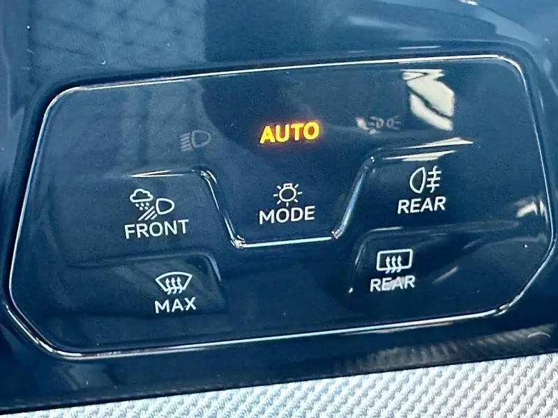 Panneau de commandes d'éclairage et désembuage avec mode automatique éclairé dans une Volkswagen Golf noire 2025.