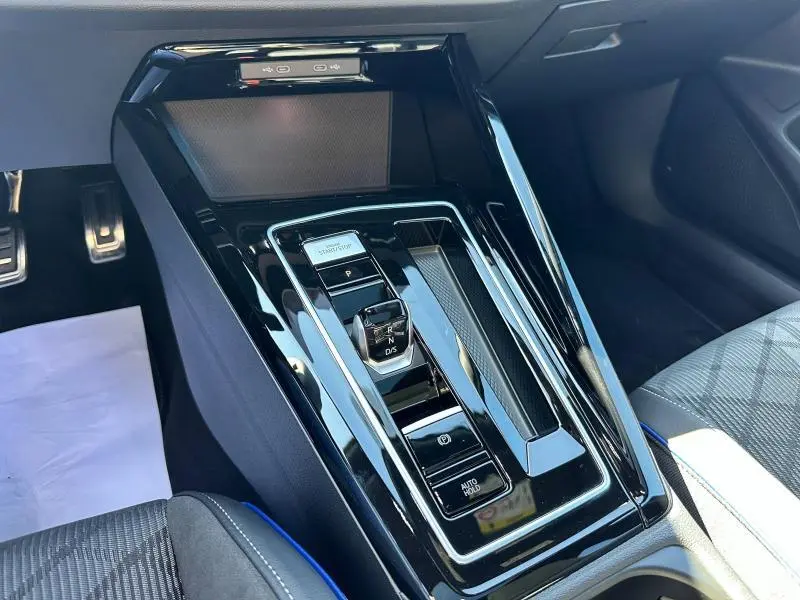 Vue rapprochée de la console centrale noire brillante de la Volkswagen Golf 1.5 eTSI R-Line Edition 2025 avec levier de vitesses automatique.
