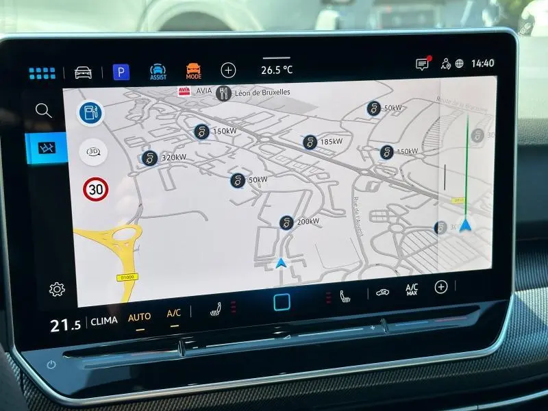 Écran tactile du système de navigation de la Volkswagen Golf 1.5 eTSI noir, affichant une carte avec stations de recharge électrique.