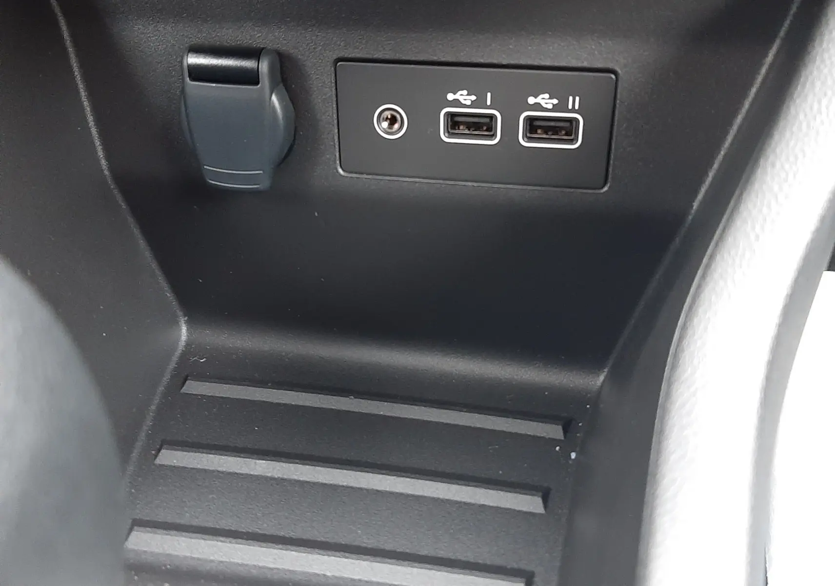 Gros plan sur la console centrale noire avec deux ports USB et une prise 12V dans une Renault Clio V hybride.