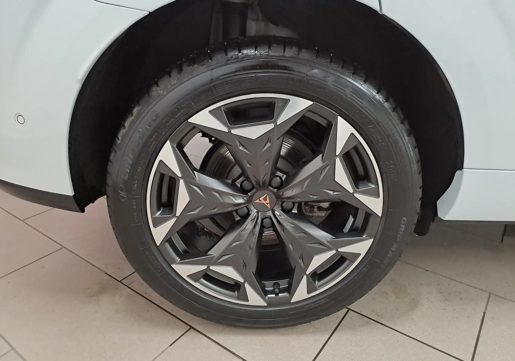 Gros plan sur la jante 19'' Cosmic usinée du côté arrière droit d'une CUPRA TERRAMAR Blanc Nevada 2025.