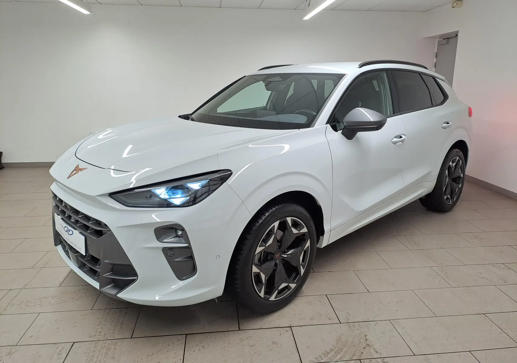 Vue 3/4 avant droite du CUPRA TERRAMAR blanc Nevada avec jantes 19'' Cosmic usinées et feux allumés.