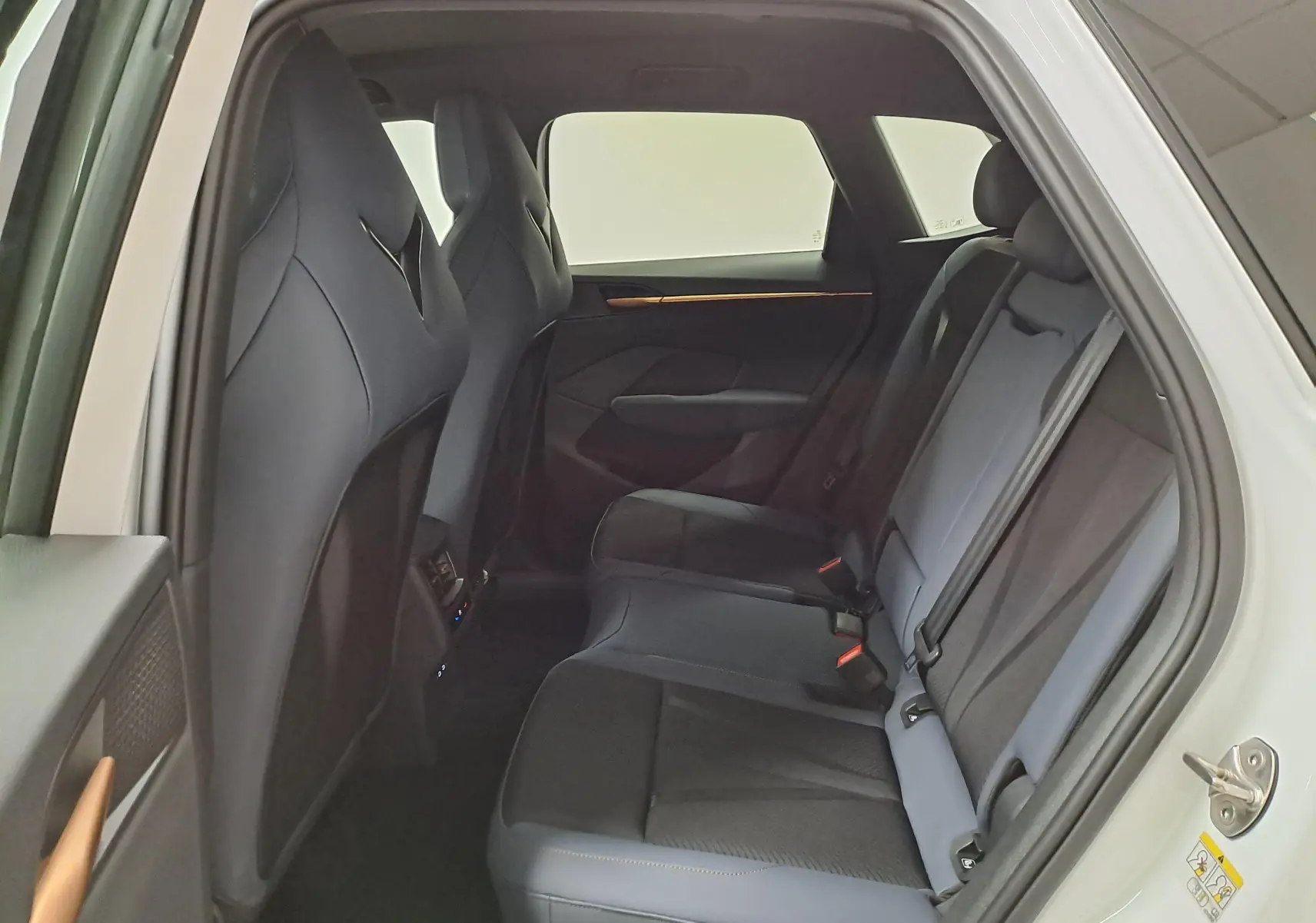 Vue intérieure arrière côté droit du CUPRA TERRAMAR blanc Nevada, montrant les sièges arrière en tissu et cuir noir.