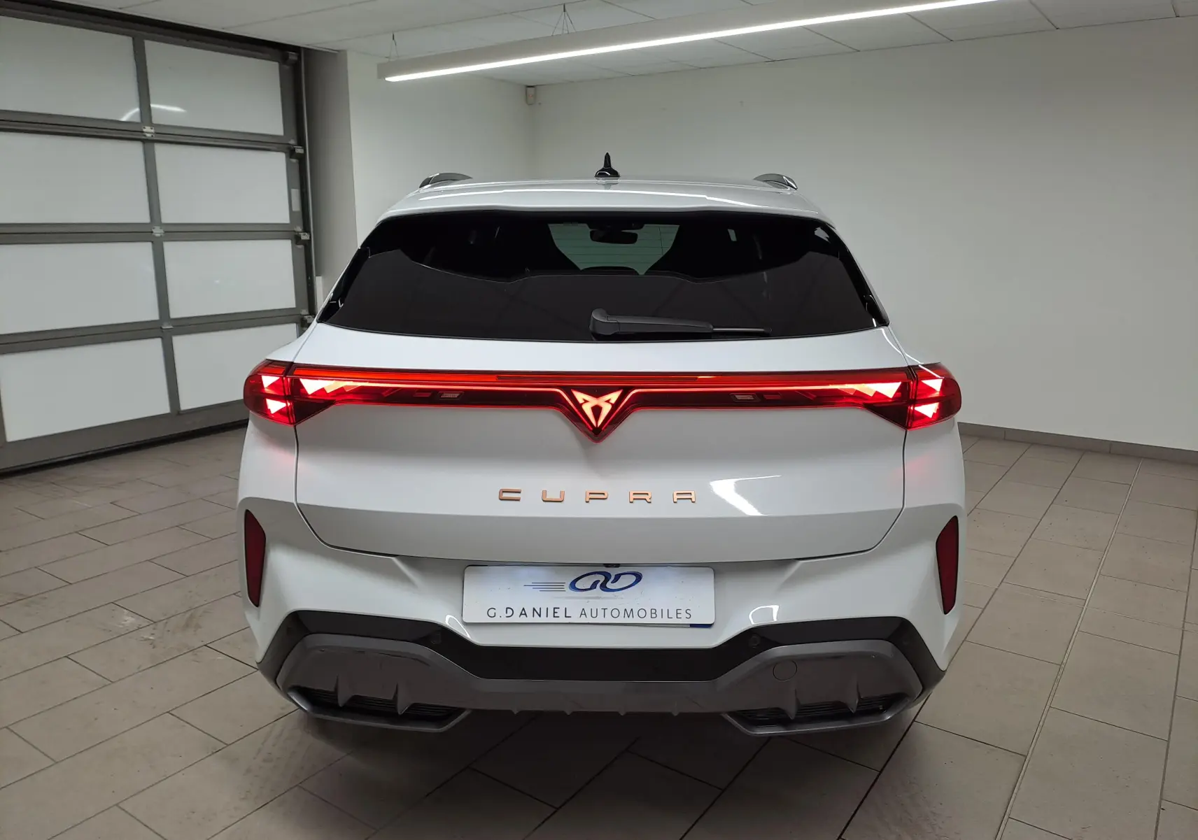 Vue arrière d'une CUPRA TERRAMAR blanche Nevada 2025 avec feux LED continus et logo CUPRA illuminé rouge.