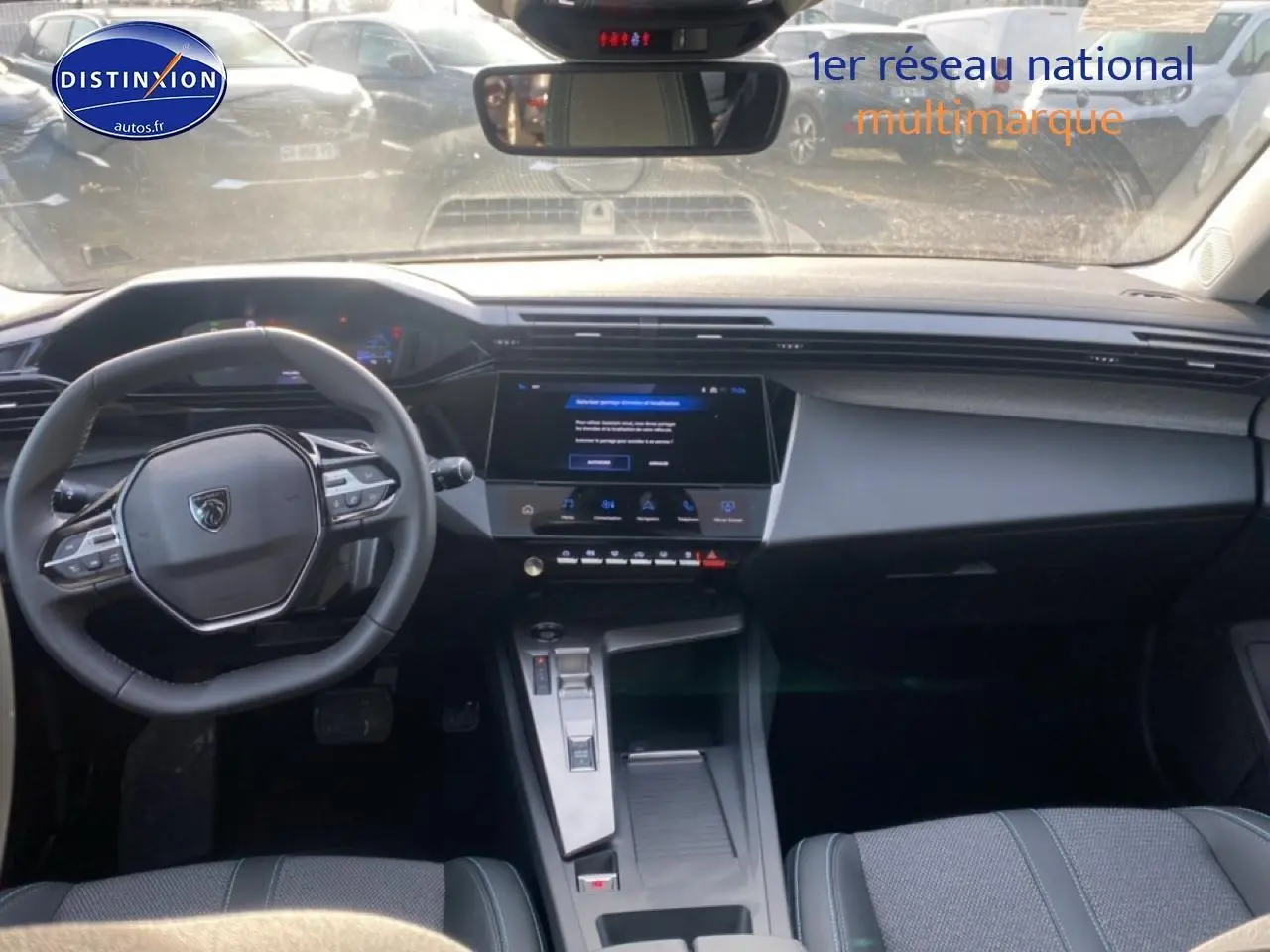 Vue intérieure avant du Peugeot 308 SW gris sellenium, montrant le volant multifonction et l'écran tactile central.