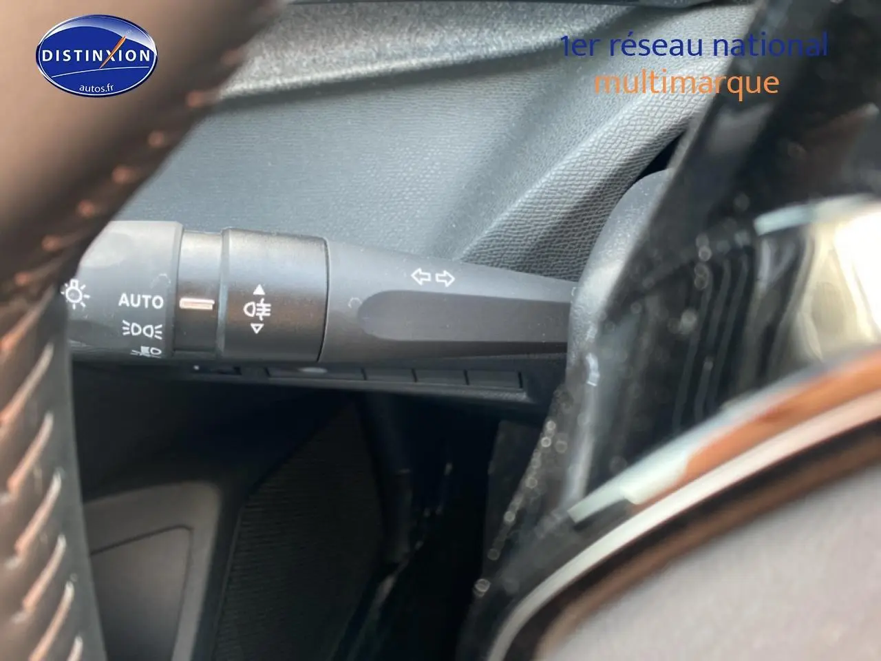 Gros plan sur la commande des phares et clignotants à gauche du volant dans un Peugeot 308 SW gris sellenium.