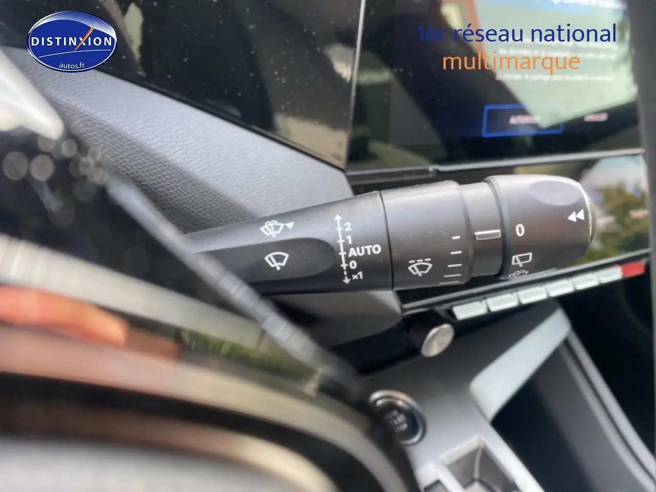 Gros plan sur la commande d’essuie-glace à gauche du volant dans l’habitacle du Peugeot 308 SW gris sélénite.