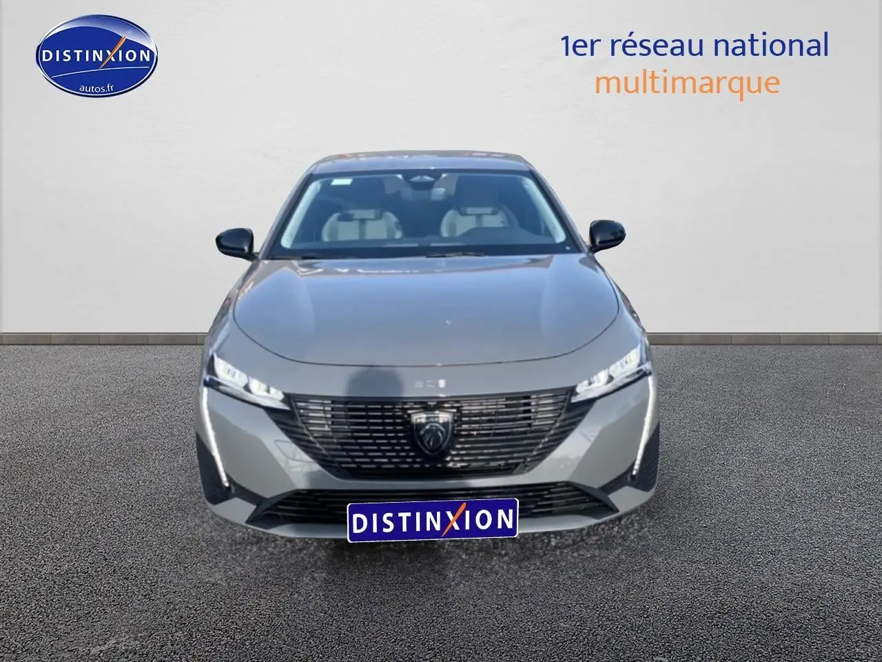 Vue avant d'une Peugeot 308 SW gris sélénite avec calandre noire et phares LED fins allumés.