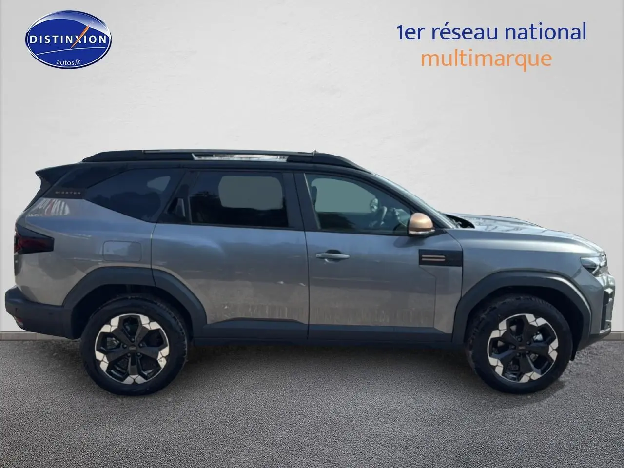 Profil droit du Dacia Bigster gris schiste avec jantes alu et toit noir contrasté sur fond neutre.