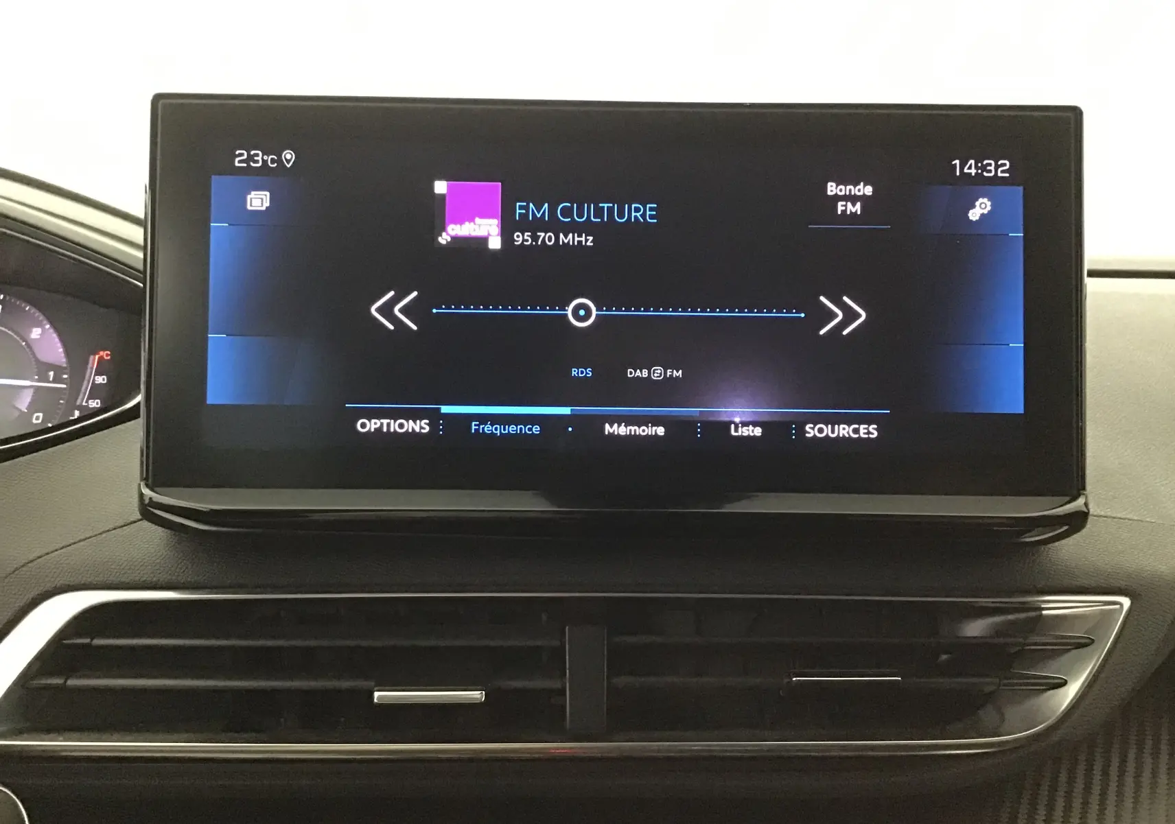 Écran tactile central du tableau de bord du Peugeot 5008 blanc nacré, affichant la radio FM à 95,70 MHz.