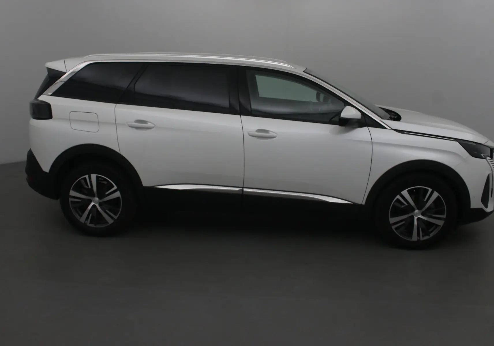 Peugeot 5008 blanc nacré vu de profil côté gauche, SUV 7 places avec jantes alliage et vitres teintées.