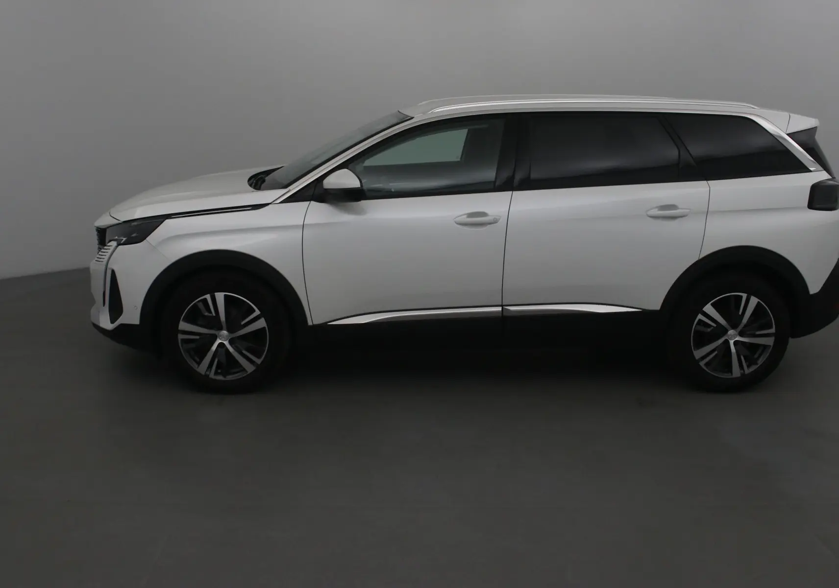 Peugeot 5008 blanc nacré vu de profil côté gauche, avec jantes alliage et vitres teintées.
