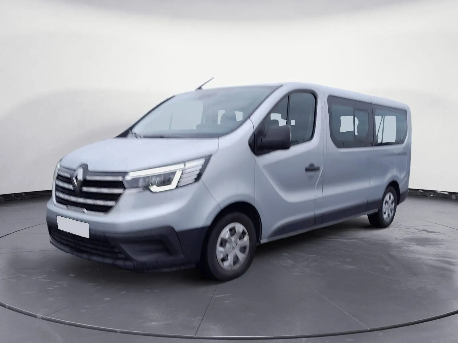Renault Trafic Combi gris clair métal vu en 3/4 avant droit, avec calandre noire et vitres latérales teintées.