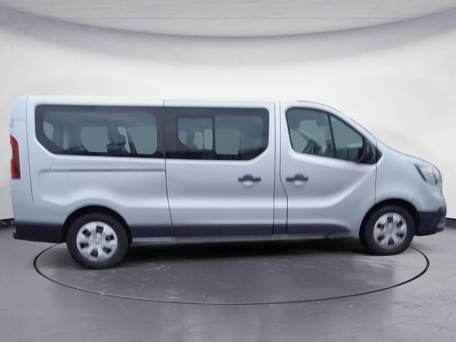 Profil côté droit du Renault Trafic Combi gris clair métal 2023, montrant ses grandes fenêtres et portes coulissantes.