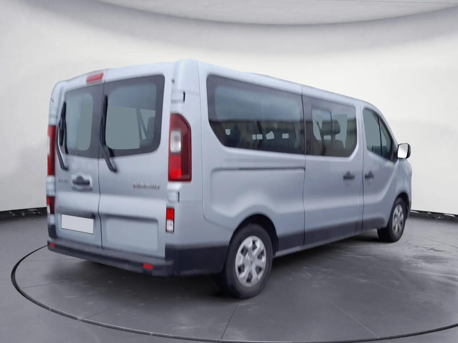 Renault Trafic Combi gris clair métal vu en 3/4 arrière droit, avec grandes vitres latérales et portes arrière vitrées.