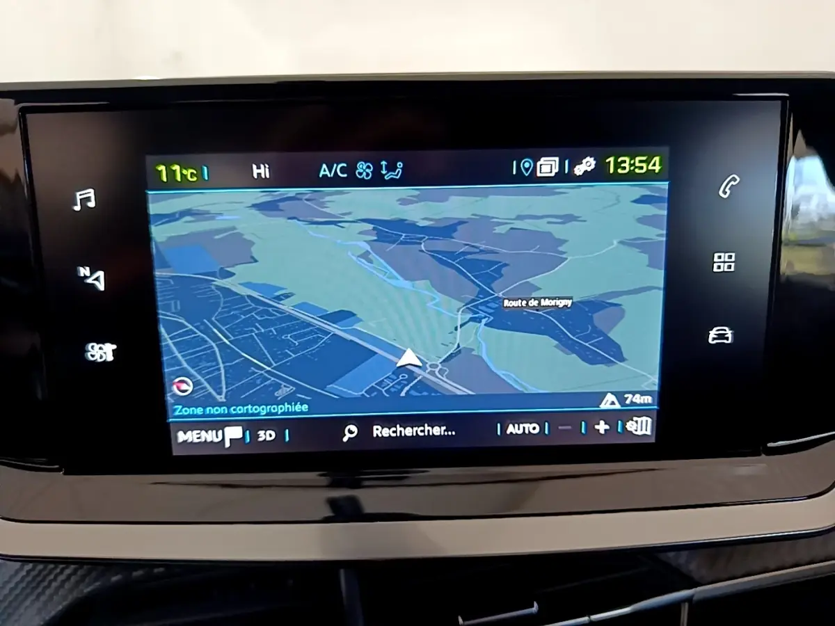 Écran tactile central affichant la navigation GPS dans l’habitacle d’une Peugeot 208 électrique blanche, vue de face.