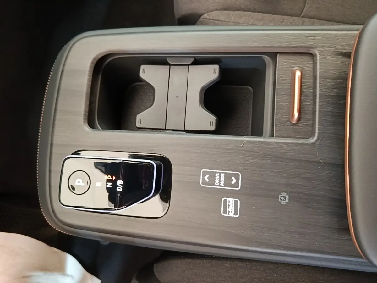 Gros plan sur la console centrale noire du Nissan Ariya 63kWh 218ch Engage avec sélecteur de vitesse et rangement intégré.