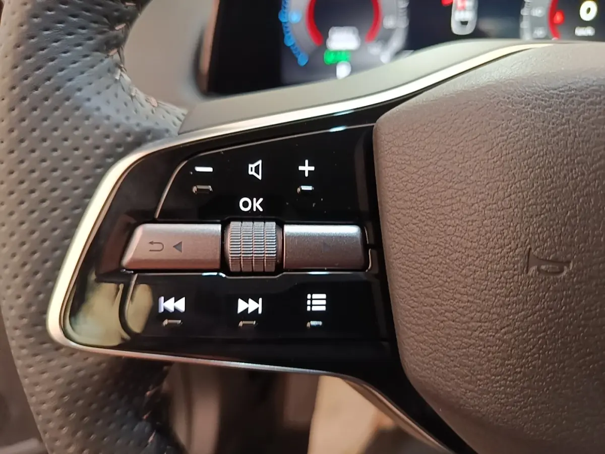 Gros plan sur les commandes multifonctions du volant cuir noir du Nissan Ariya 63kWh 218ch Engage 2026.