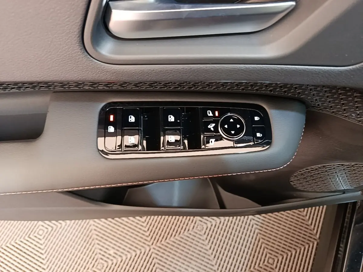 Gros plan sur les commandes de vitres et rétroviseurs sur la porte côté gauche du Nissan Ariya noir 2026.