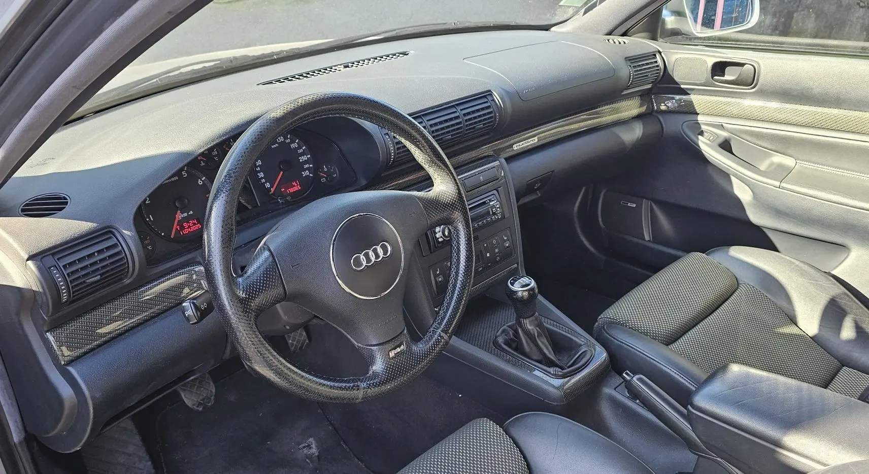 Intérieur noir de l'Audi RS4 Avant (B5) 2001, vue côté conducteur montrant volant, tableau de bord et levier de vitesses manuel.