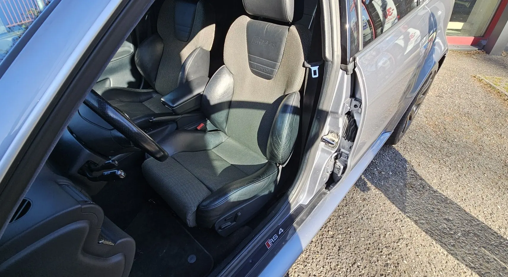 Vue intérieure côté conducteur d'une Audi RS4 Avant grise de 2001, siège sport Recaro avec logo RS4 brodé.