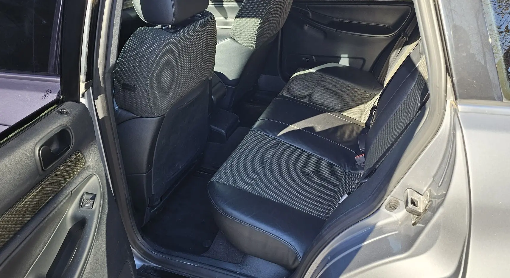 Vue intérieure côté droit arrière de l'Audi RS4 Avant gris, montrant les sièges arrière en cuir noir et tissu.