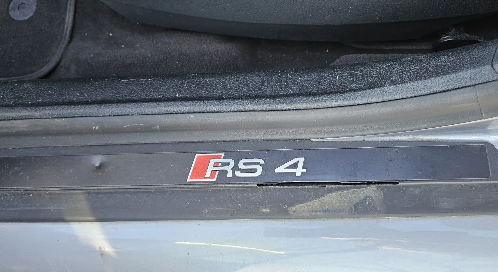 Plaque de seuil de porte avec logo RS4 sur une Audi RS4 Avant grise, vue en gros plan côté gauche intérieur.