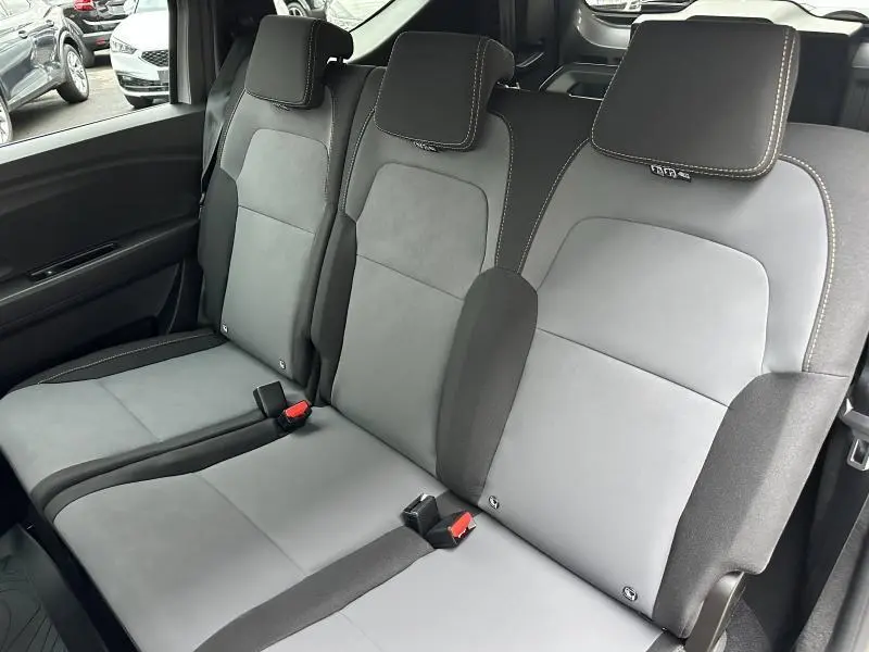 Vue intérieure côté droit des sièges arrière gris clair et foncé du Dacia Jogger 2024 avec appuie-tête intégrés.