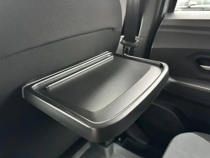 Tablette rabattable noire fixée au dos du siège avant dans l'habitacle d'une Dacia Jogger gris Schiste métallisé