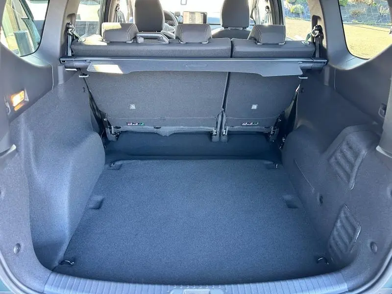 Coffre spacieux vu de l'arrière du Dacia Jogger gris Schiste avec banquette arrière et cache-bagages.