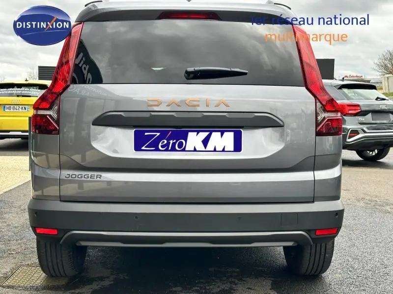 Vue arrière d'une Dacia Jogger gris schiste métallisé avec feux arrière LED et logo Dacia cuivré visible.