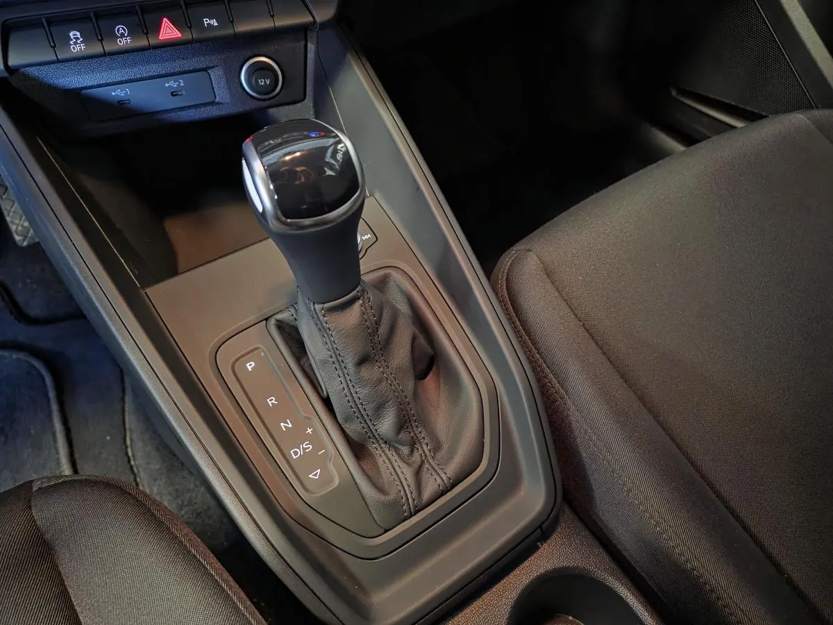 Gros plan sur la console centrale et levier de vitesses automatique de l'Audi A1 Sportback 2024 en tissu noir.